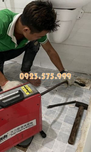 Nhân viên thông tắc cống nhà vệ sinh cho khách hàng mà không cần đục phá