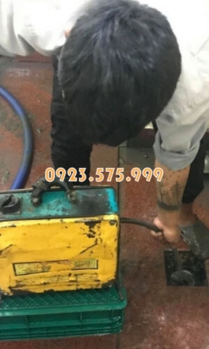 Nhân viên vừa thông tắc vừa tính toán độ dài đường ống